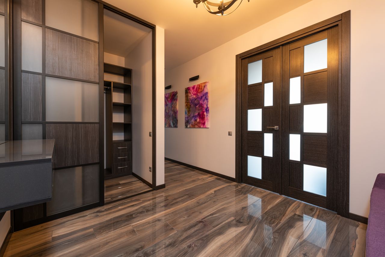 about-02 Contemporary room interior with closet on floor reflecting door against paintings on wall in light house