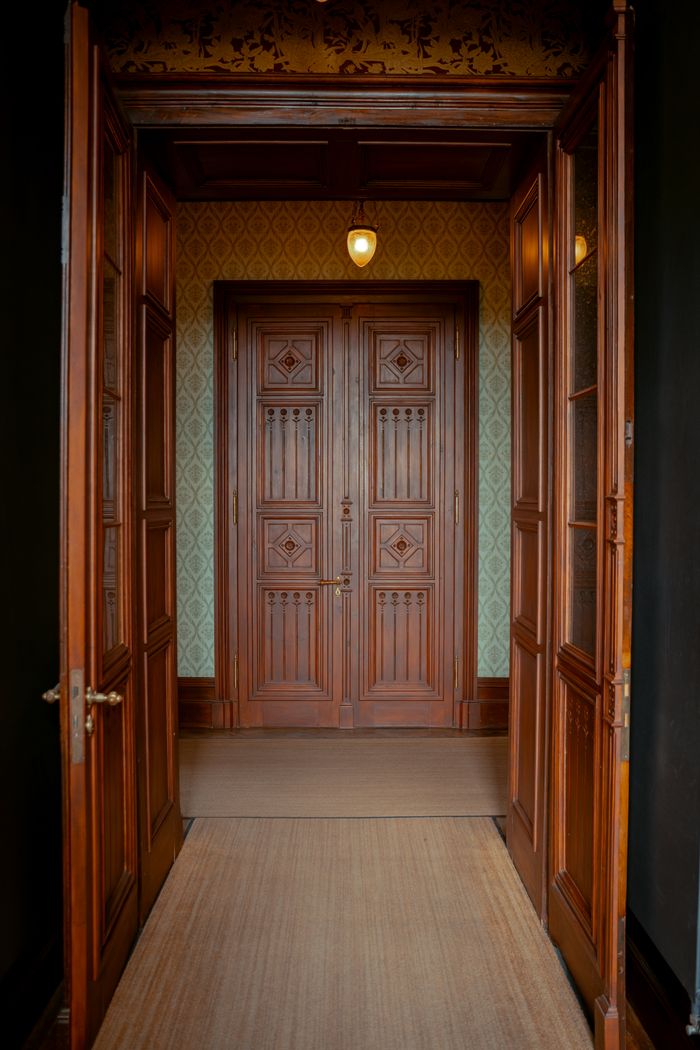 Elegant wooden corridor with vintage double doors and intricate design in Germany.